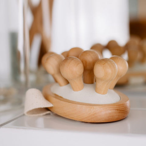 Seitenansicht einer natürlichen Cellulite-Bürste mit großen Holznoppen und einer Handschlaufe aus nachhaltiger Baumwolle.